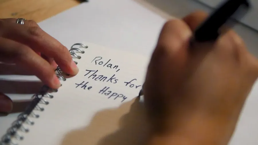 Oscar writing a number on a box in marker
